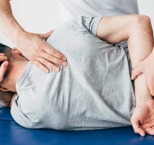 back-view-of-chiropractor-massaging-back-of-man-lying-on-massage-table-in-hospital.jpg